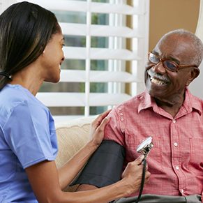 Nurse taking blood pressure of long term care facility resident